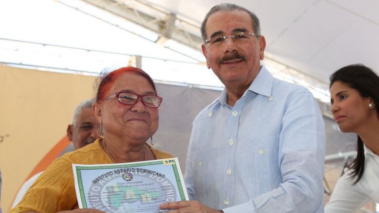 Danilo Medina entre título de propiedad a mujer
