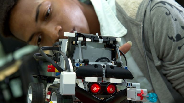 un joven mientras construye un robot