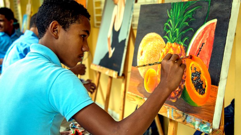 Joven del liceo Eugenio María de Hostos en Boca Chica mientras pinta