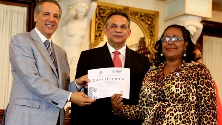 Ministros Administrativo de la Presidencia, José Ramón Peralta y de Administración Pública, Ramón Ventura Camejo entregan certificado a empleada pública